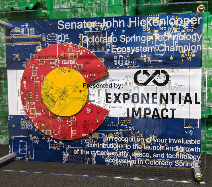 Circuit Board Award plaque for Senator John Hickenlooper recognizing his contributions to the Colorado Springs Technology Ecosystem, with a green circuit board background.